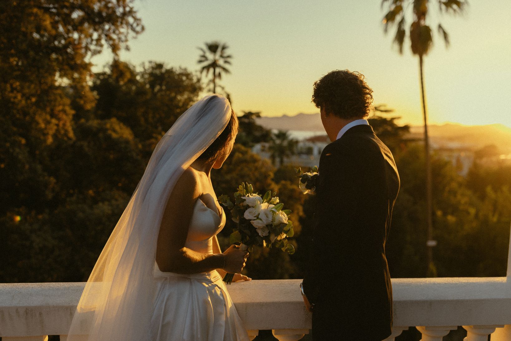 Couple de dos le soir, l'homme arrange la robe de la femme